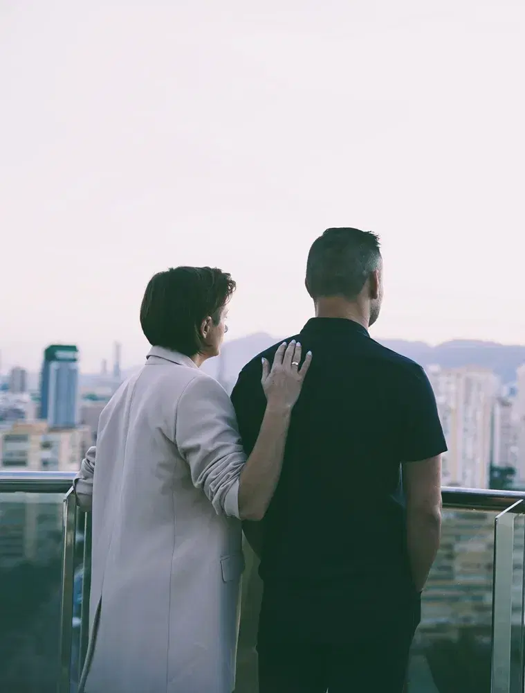 Para kobieta i mężczyzna na balkonie z widokiem na miasto i morze w Hiszpanii. Wyjazd dla par - odnówcie bliskość